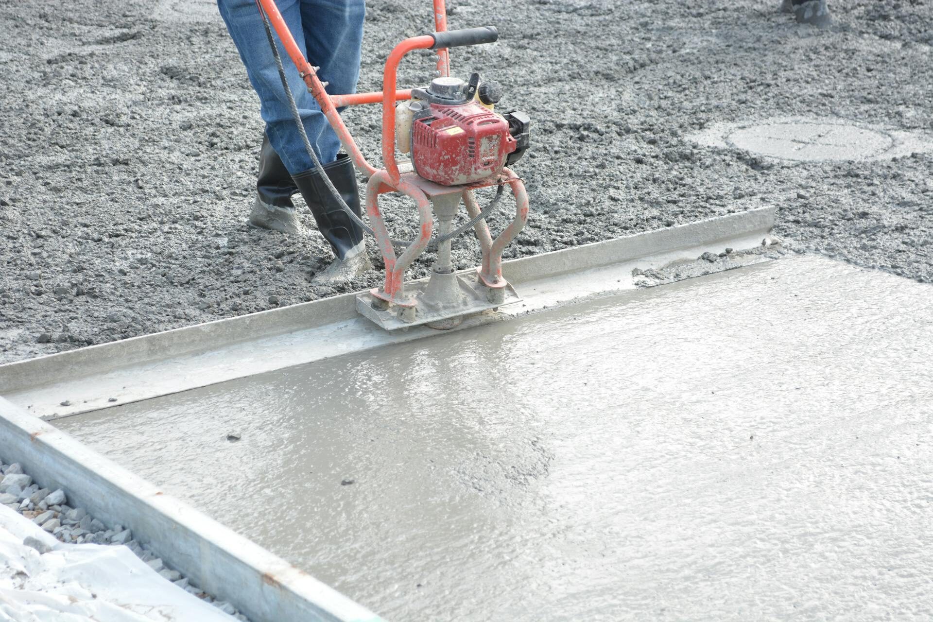 Concrete finisher running a power trowel for a smooth finished surface